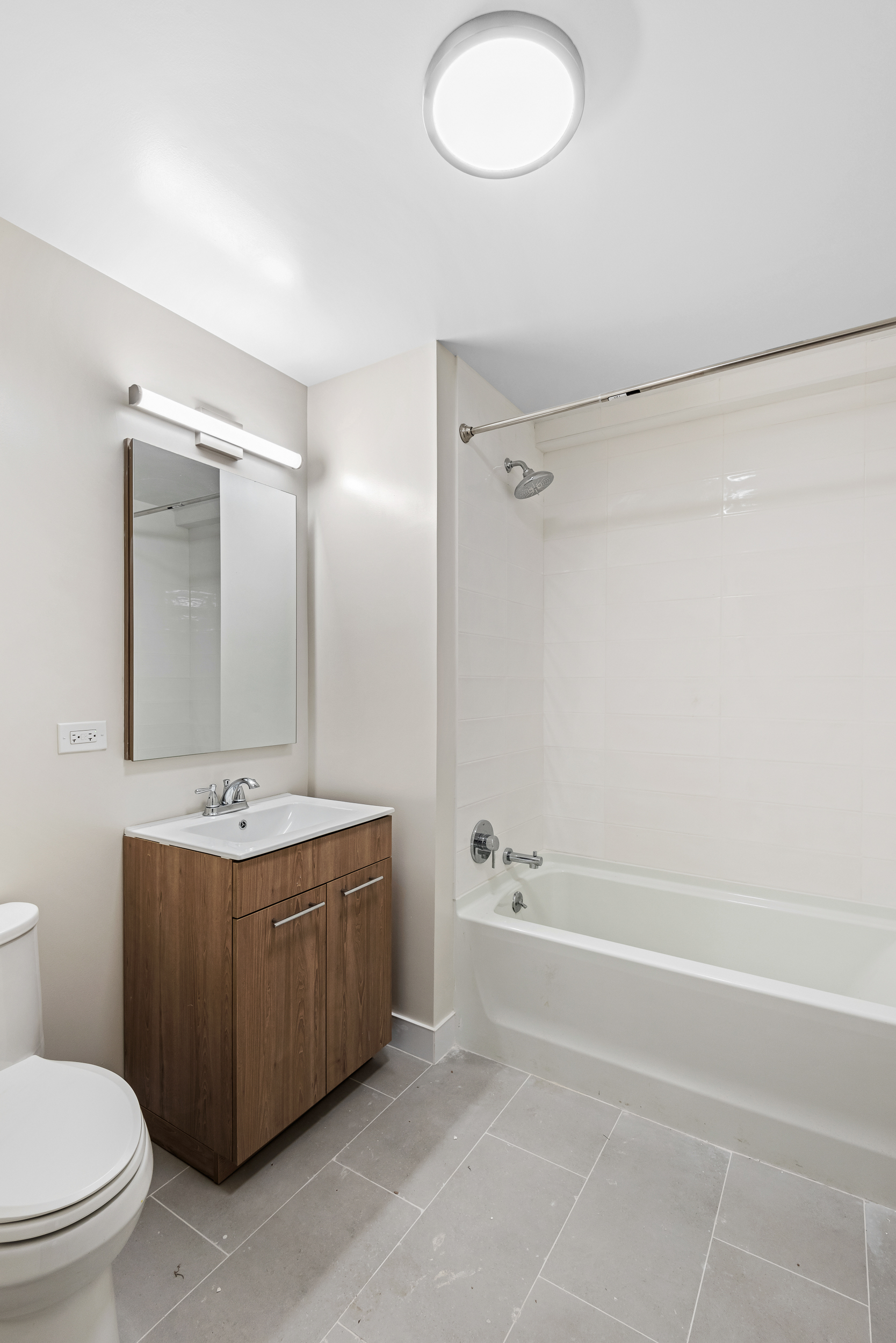 1333 Broadway, Unit 1205 Brooklyn, NY 11221 - Photo 6 of 15 a bathroom with a sink a toilet and shower