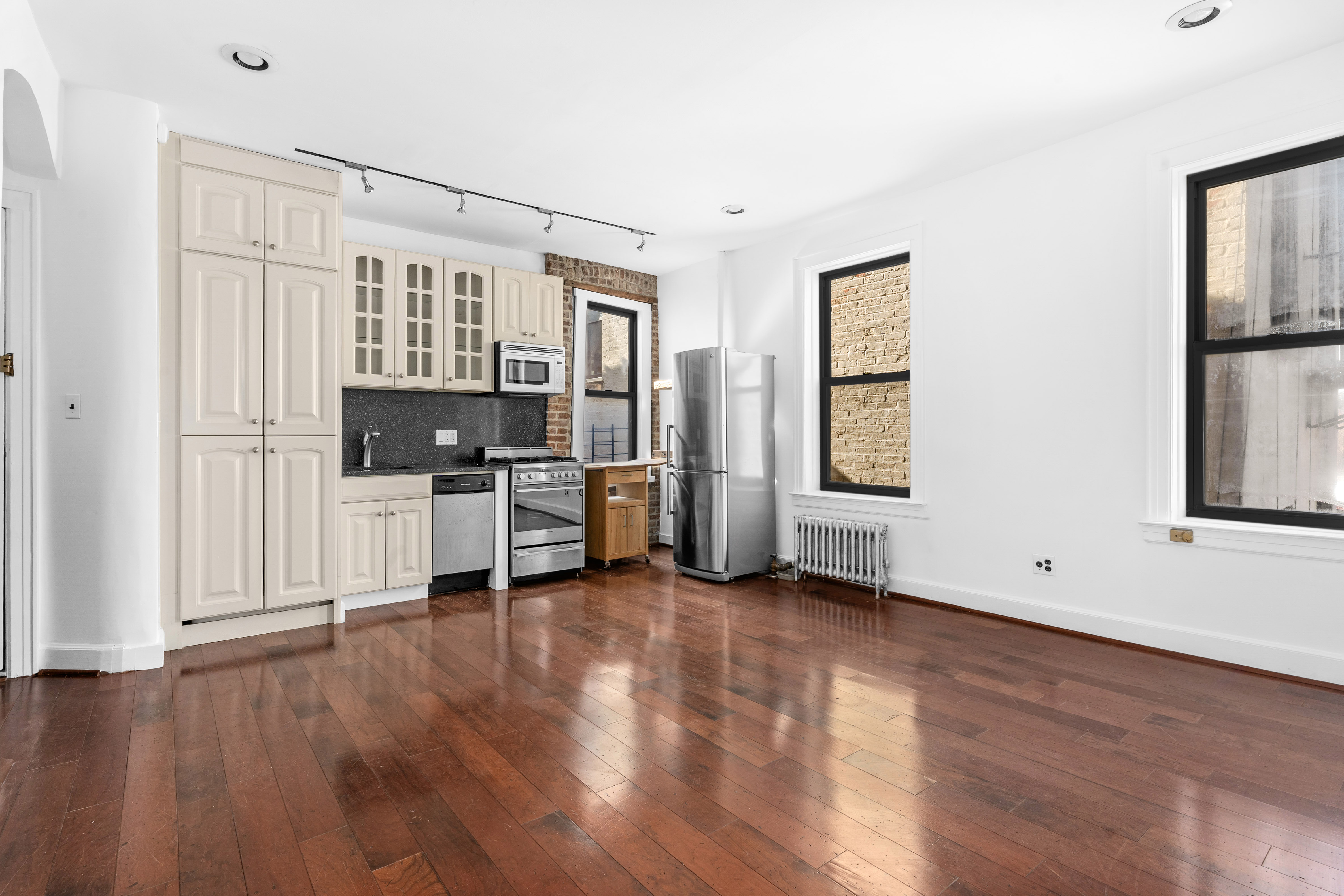 199 East 7th Street, Unit 4E Manhattan, NY 10009 - Photo 8 of 13 a view of a kitchen with furniture and wooden floor