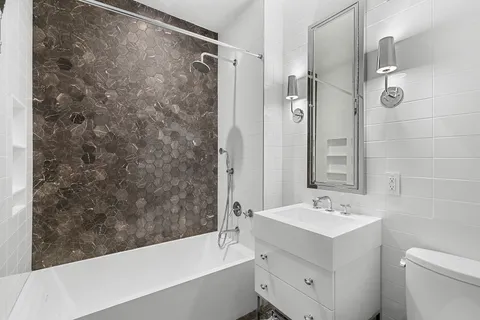 a bathroom with a sink mirror toilet and bathtub