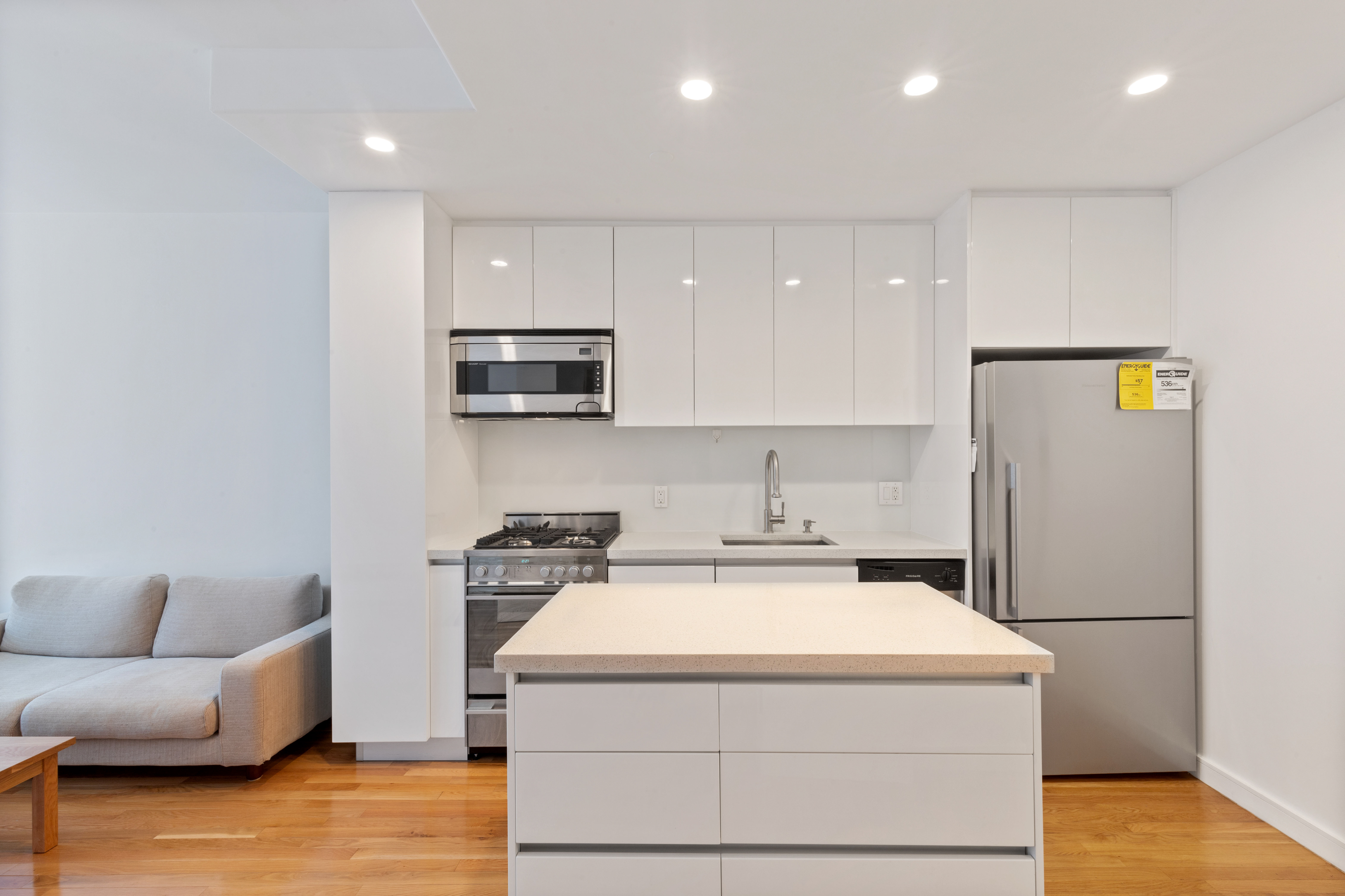 148 East 24th Street, Unit 4C Manhattan, NY 10010 - Photo 5 of 15 a view of kitchen with stainless steel appliances granite countertop a sink a stove a microwave a counter top and floors