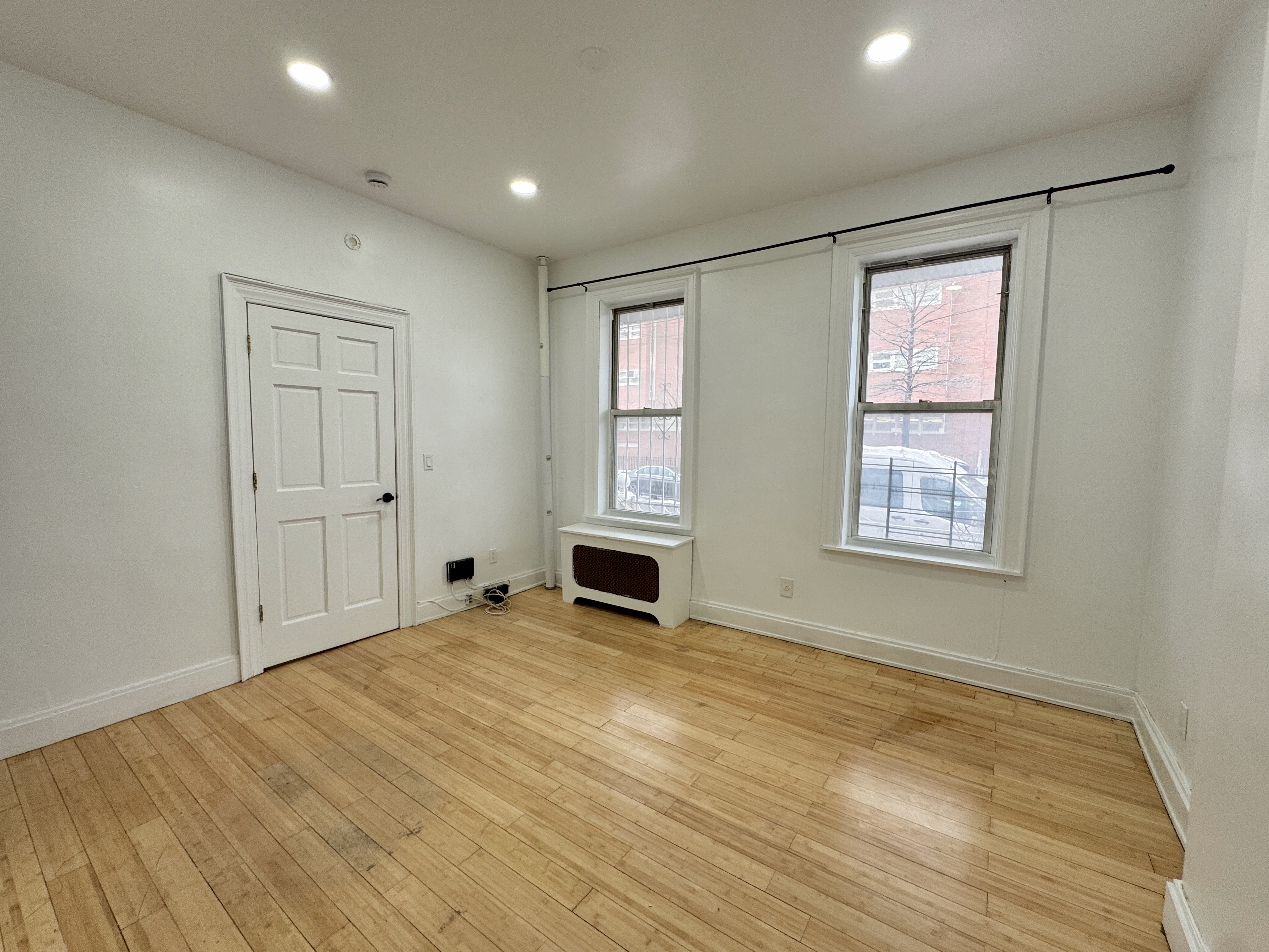347 Berriman Street, Unit 1 Brooklyn, NY 11208 - Photo 6 of 6 a view of an empty room with a window and fireplace