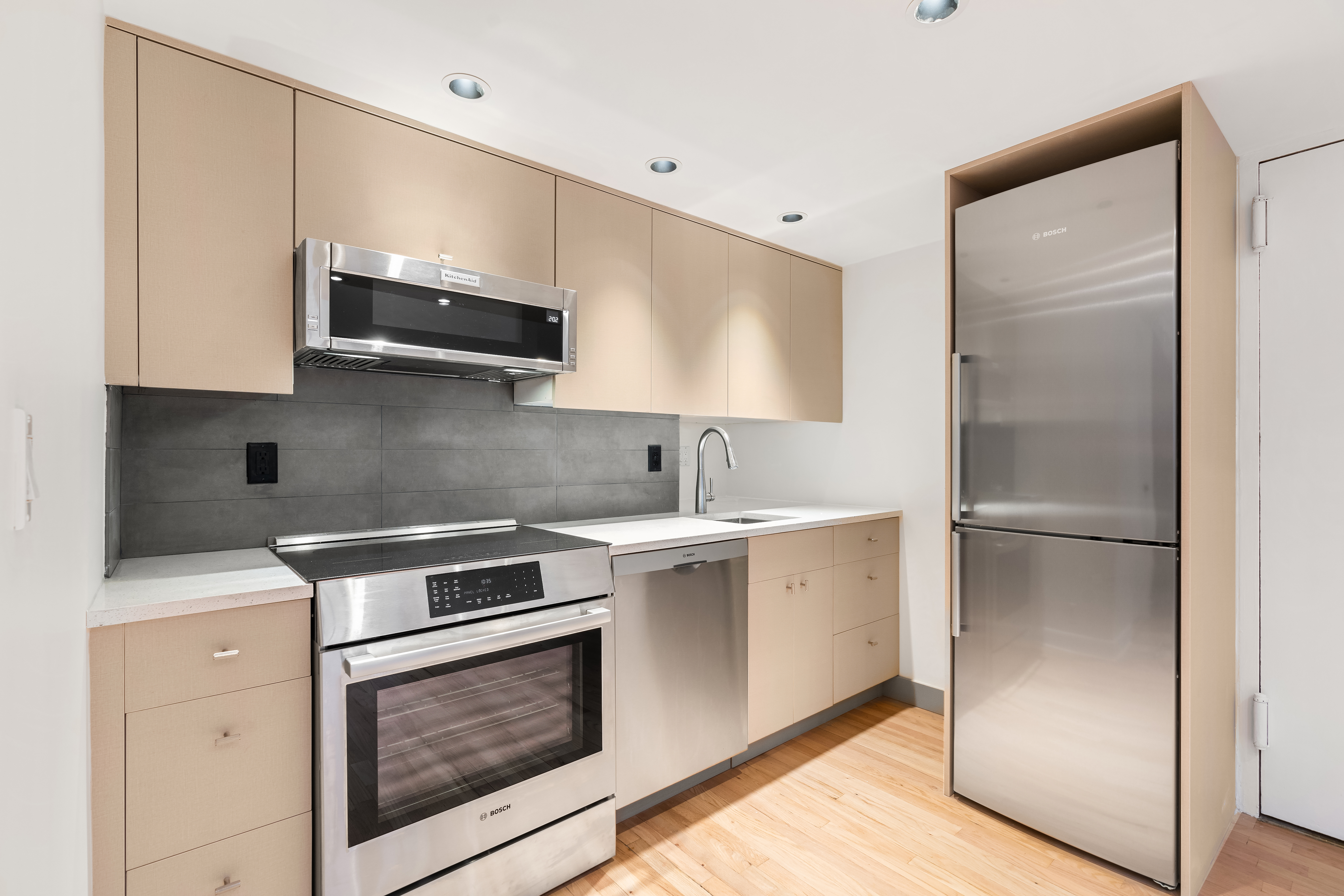 51 East 10th Street, Unit 9 Manhattan, NY 10003 - Photo 2 of 9 a kitchen with stainless steel appliances white cabinets and a stove