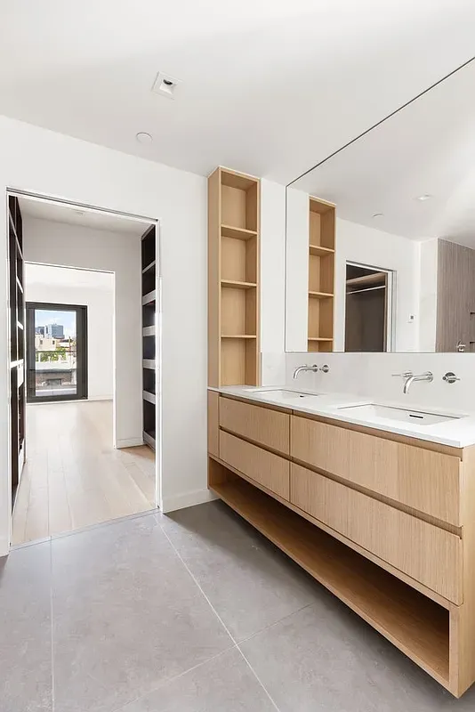 a bathroom with a double vanity sink a mirror and a bathtub