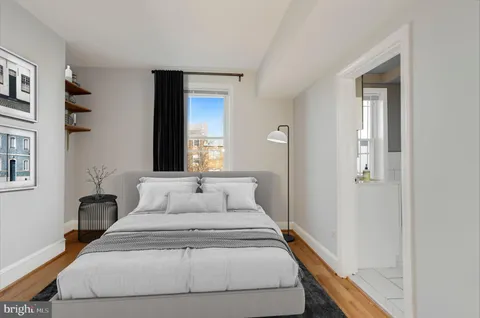 a bedroom with a bed and a potted plant