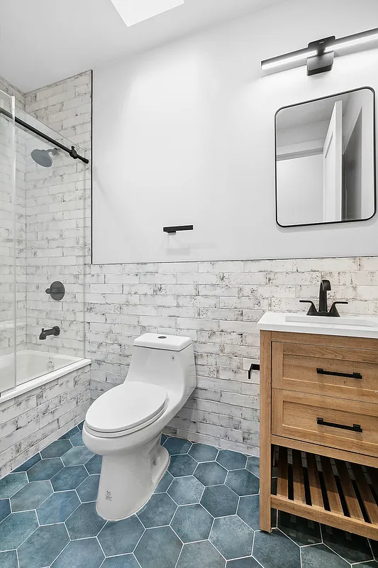 866 Bushwick Avenue, Unit 1 Brooklyn, NY 11221 - Photo 7 of 13 a bathroom with a toilet sink and mirror