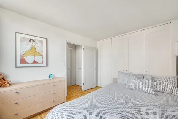 a bed room with a bed and a painting on the wall