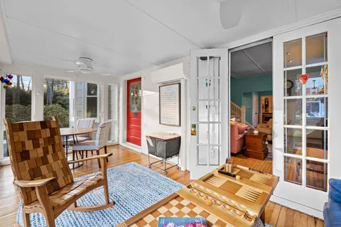a view of a patio with a dining table and chairs with wooden floor and fence