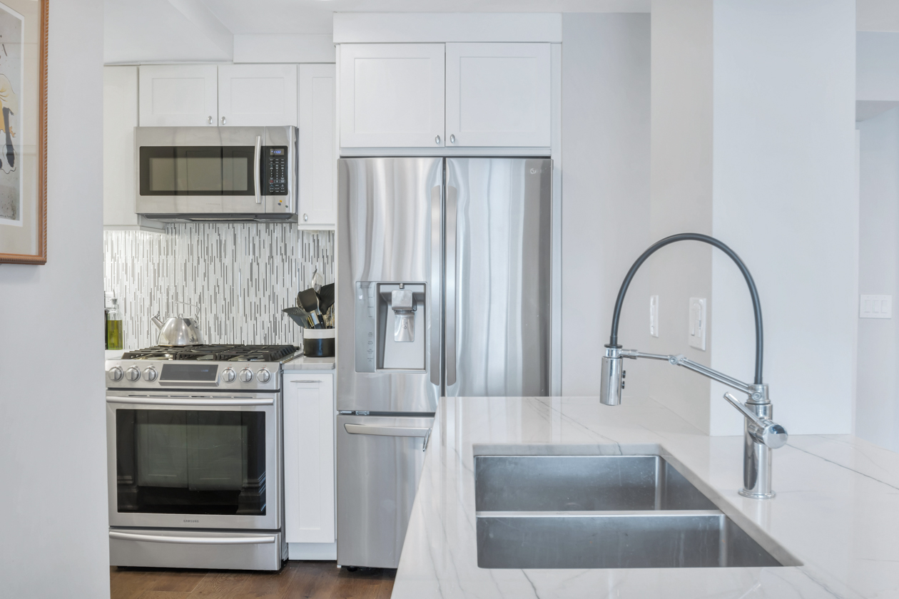 1400 5th Avenue, Unit 6K Manhattan, NY 10026 - Photo 3 of 10 a kitchen with white cabinets and stainless steel appliances