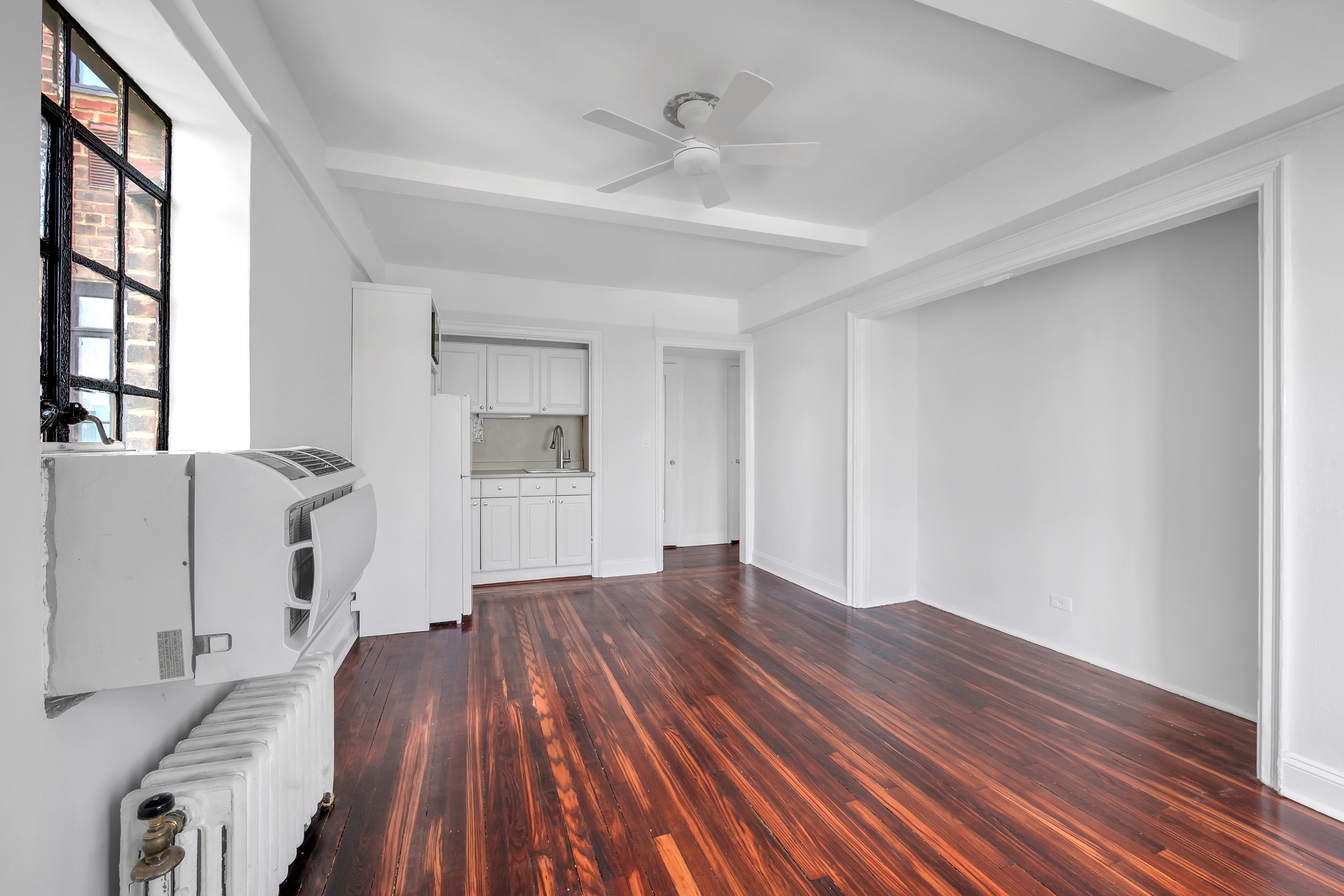 5 Tudor City Place, Unit 536 Manhattan, NY 10017 - Photo 7 of 14 wooden floor in an empty room with a window