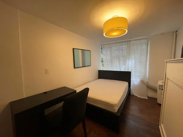 a bedroom with a bed and a painting on the wall