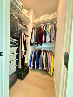 a view of walk in closet with clothes and shoes