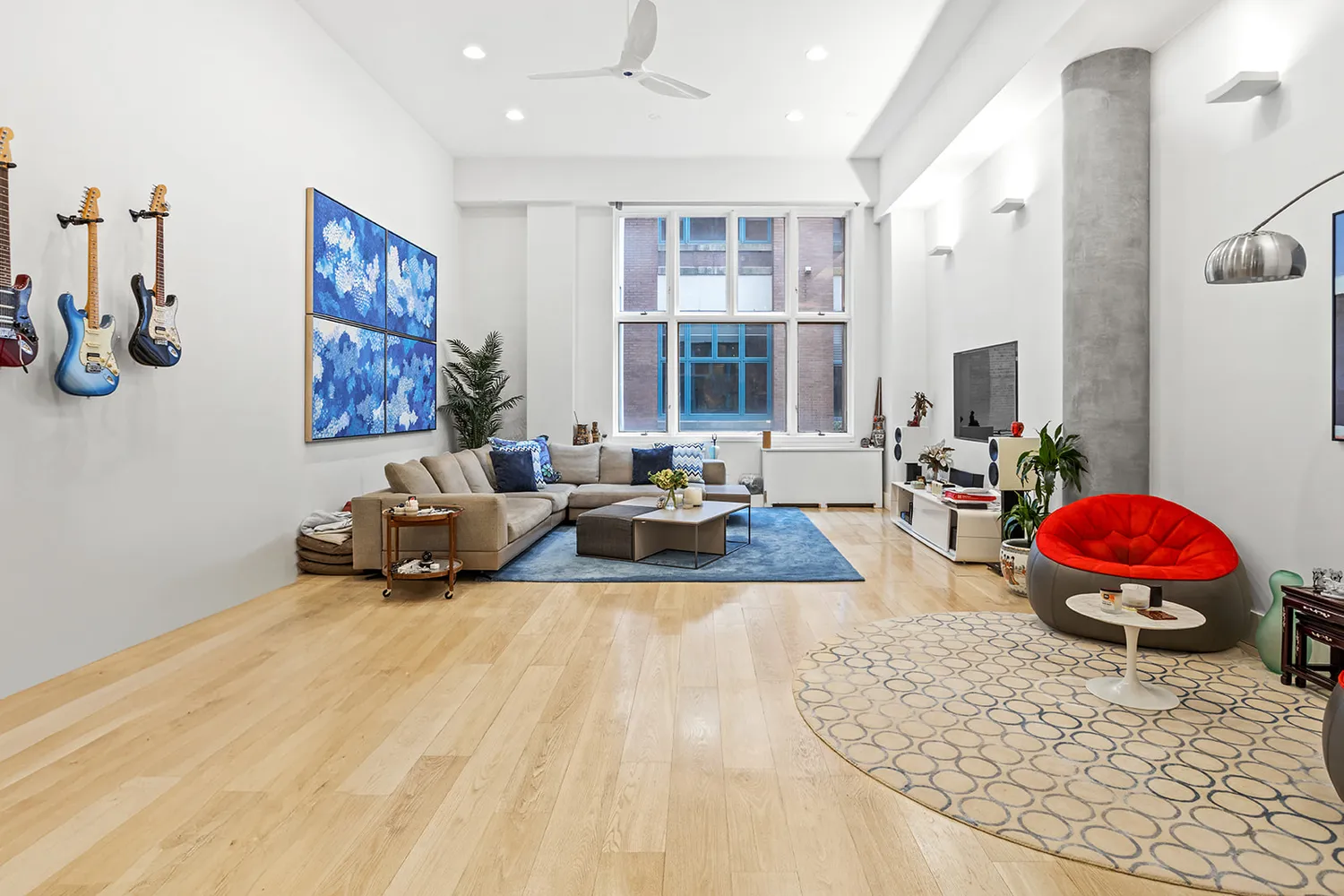 a spacious bedroom with a large bed a couch and a window