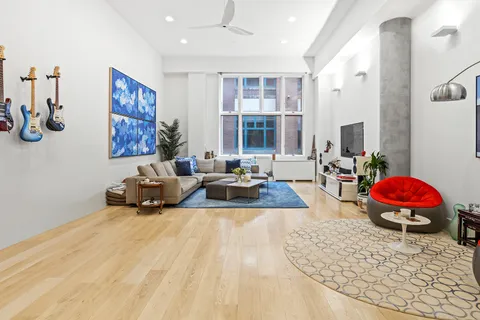 a spacious bedroom with a large bed a couch and a window