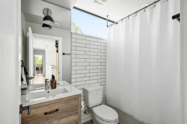 a bathroom with a sink vanity mirror and toilet