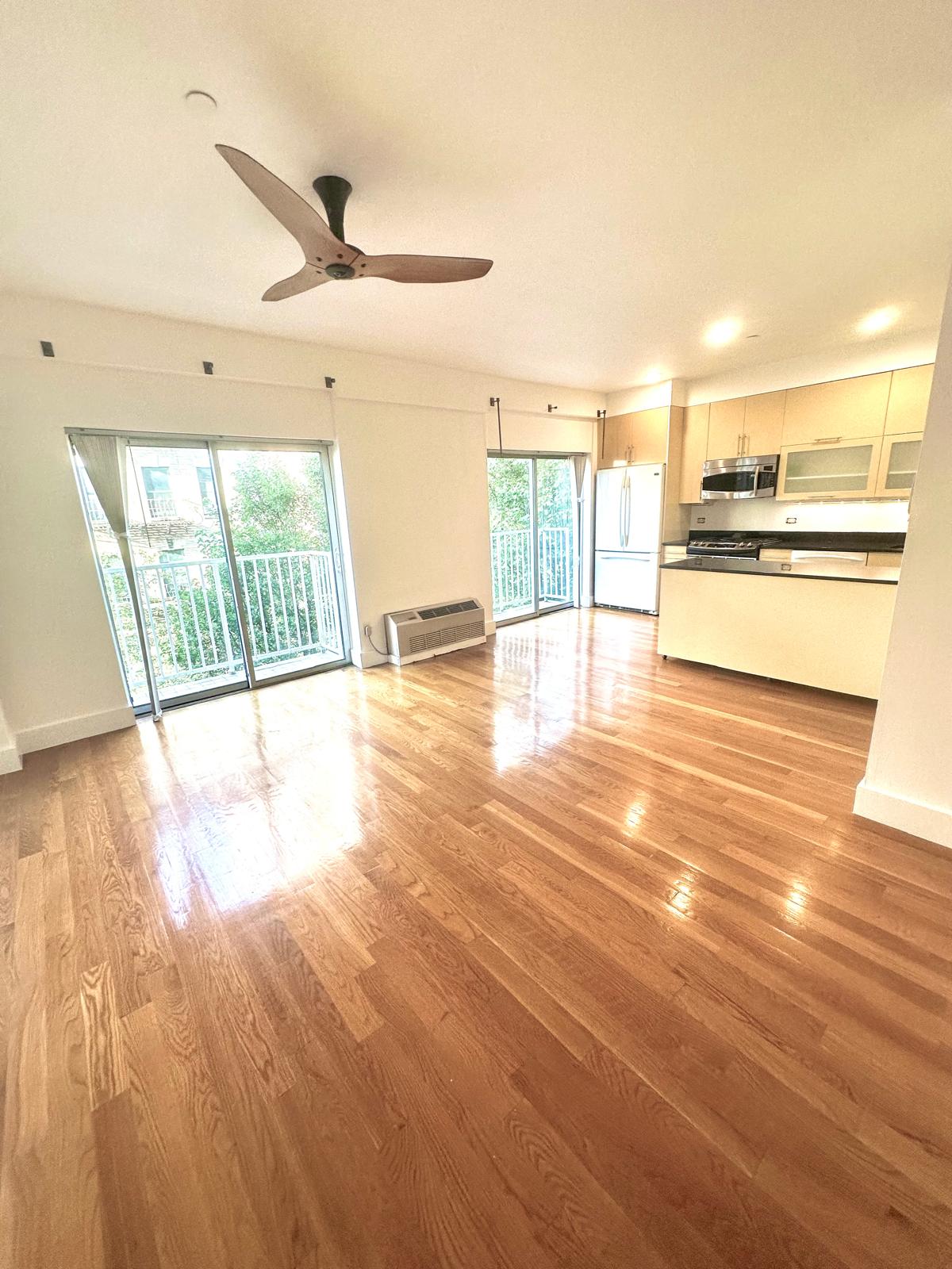 a view of a kitchen with wooden floor and a ceiling fan