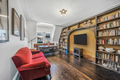 a living room with furniture a flat screen tv and a bookshelf