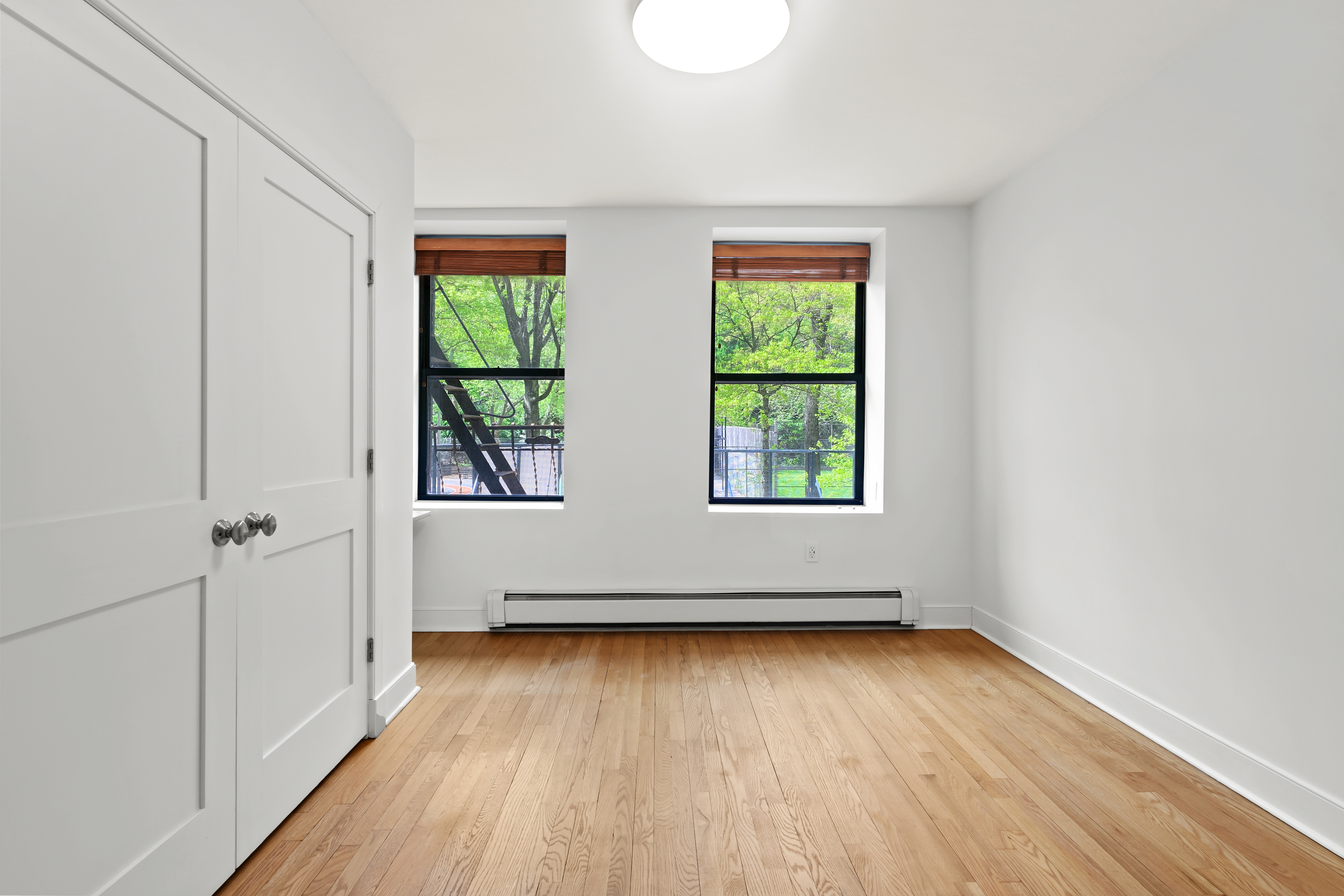 305 West 150th Street, Unit 206 Manhattan, NY 10039 - Photo 2 of 18 an empty room with wooden floor and windows