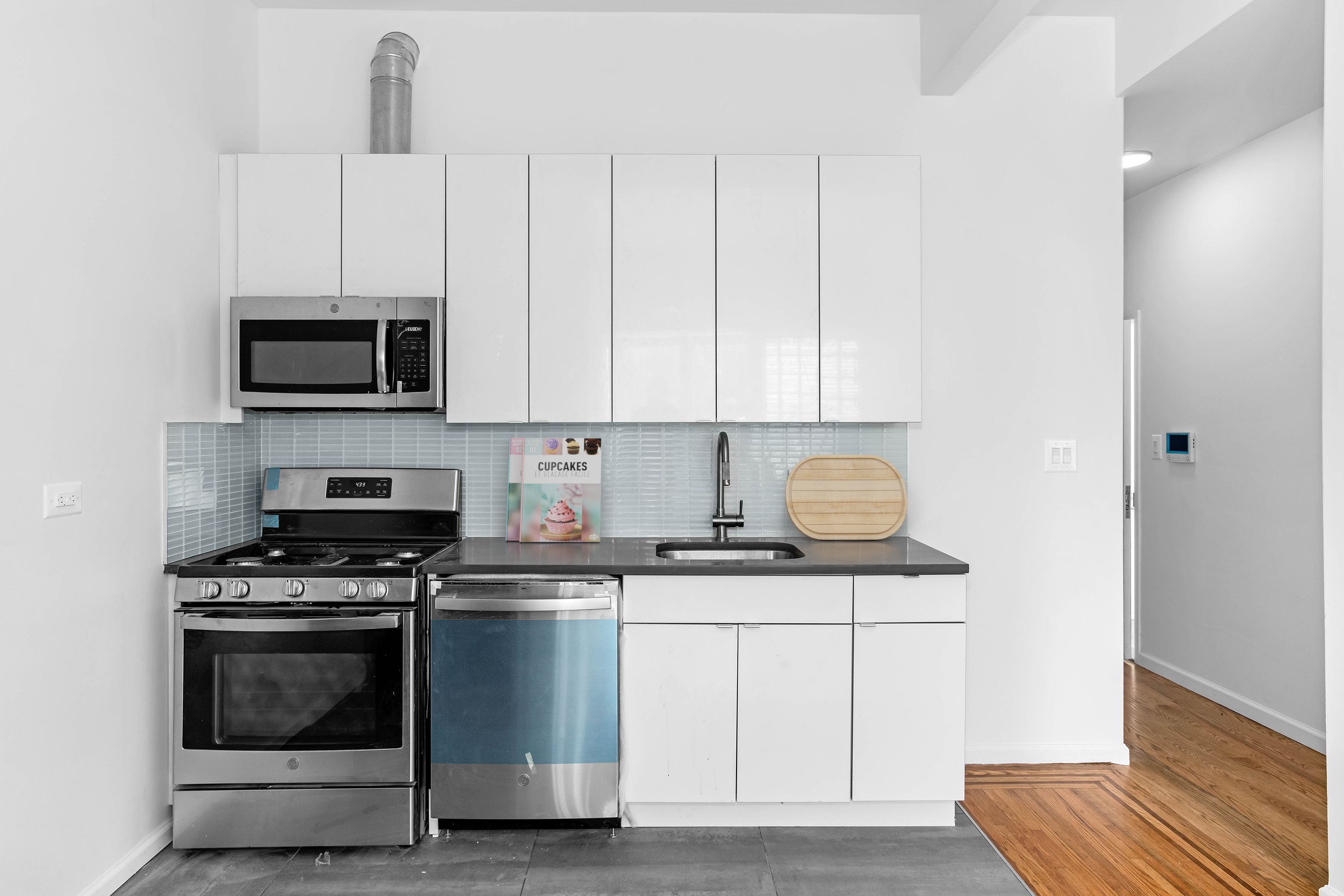 110 Bushwick Avenue, Unit 3 Brooklyn, NY 11206 - Photo 2 of 7 a kitchen with white cabinets and appliances