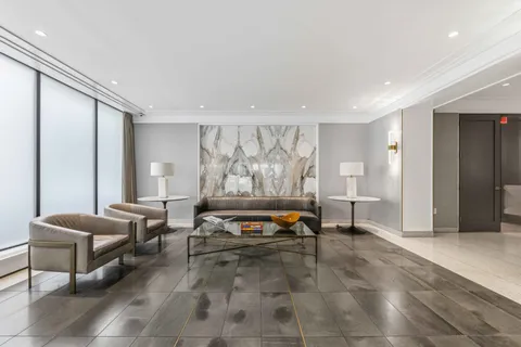 a living room with furniture a rug and a painting on the wall