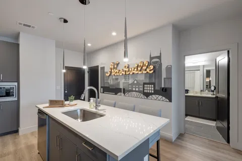 a kitchen with a sink a counter top space stainless steel appliances and cabinets
