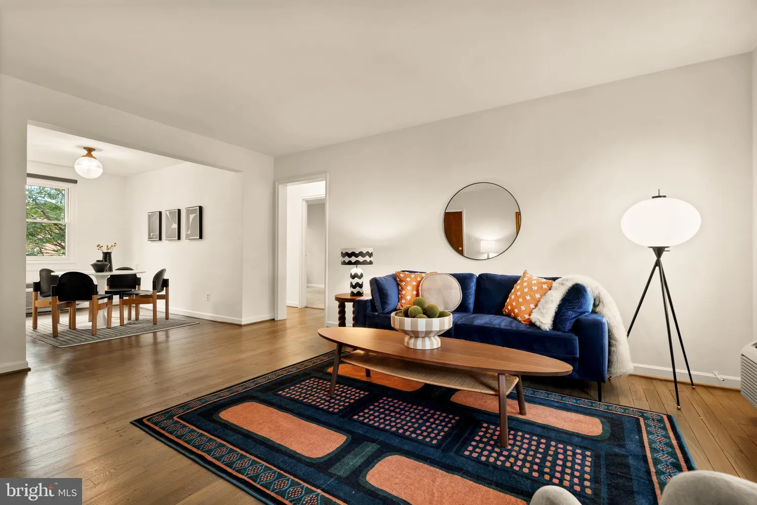 a living room with furniture a rug and a lamp