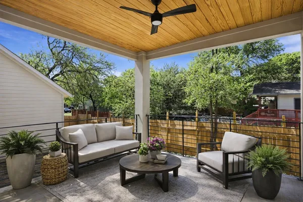 a living room with patio furniture and a potted plants