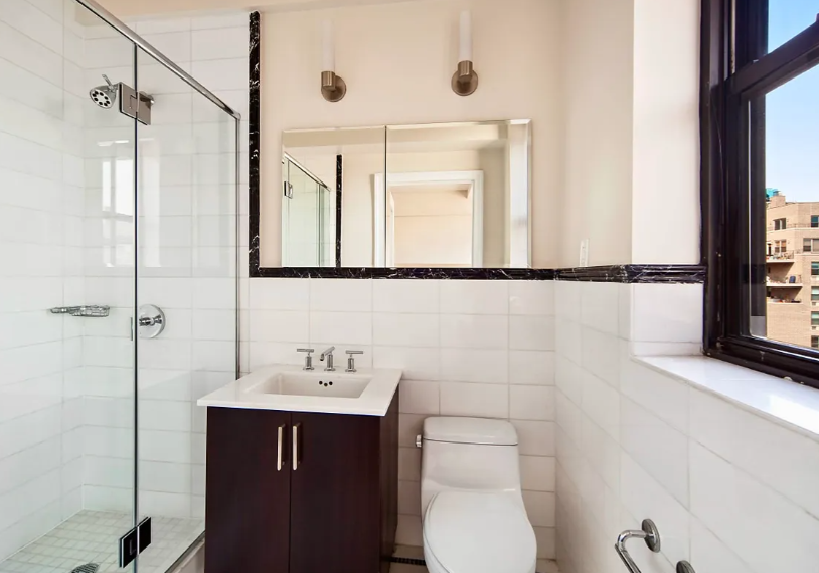 56 7th Avenue, Unit 19H Manhattan, NY 10011 - Photo 6 of 12 a bathroom with a sink a toilet and a mirror