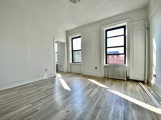 591 Vanderbilt Avenue, Unit 4 Brooklyn, NY 11238 - Photo 7 of 10 an empty room with wooden floor and windows