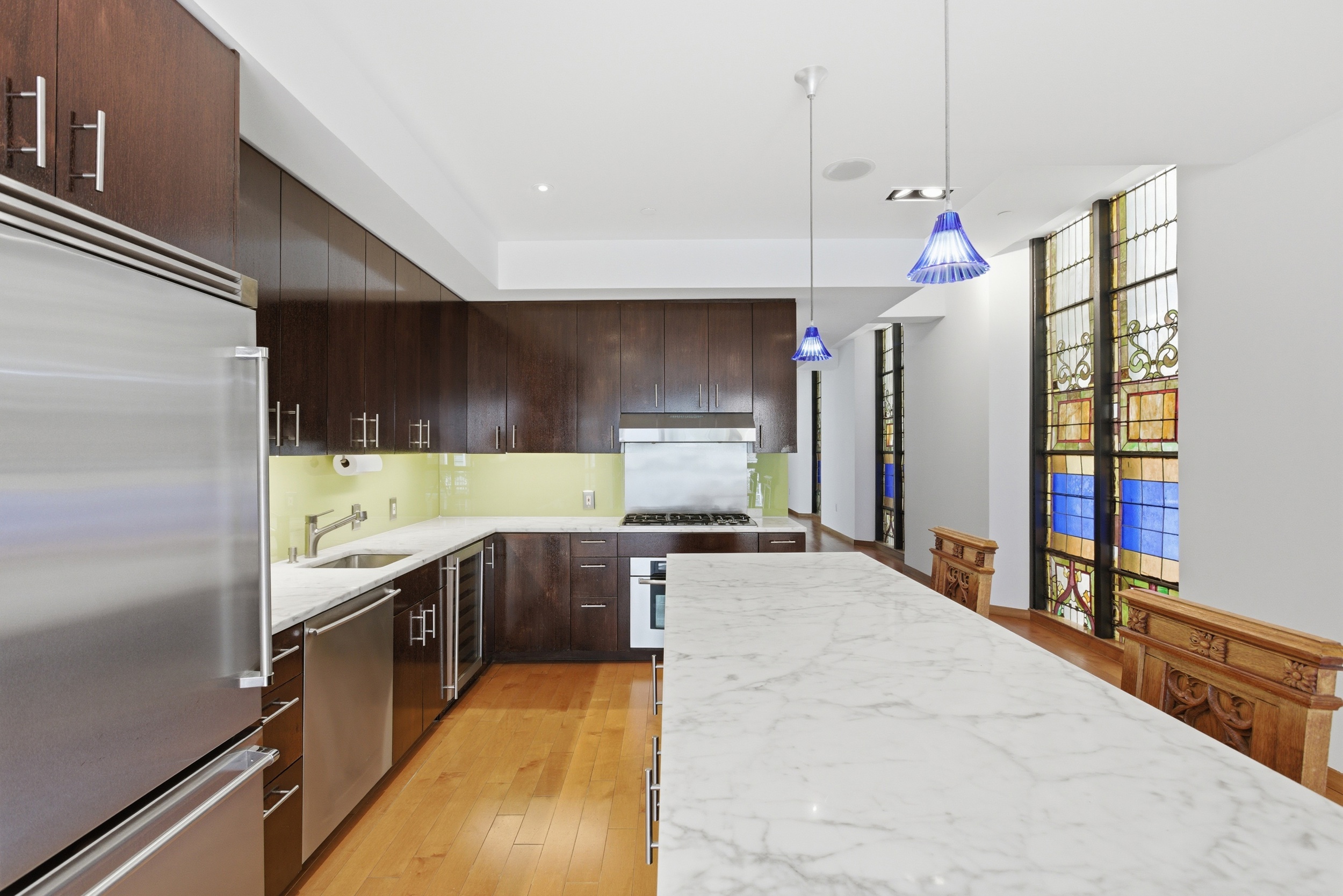 135 West 4th Street, Unit 3W Manhattan, NY 10012 - Photo 9 of 24 a kitchen with stainless steel appliances granite countertop a sink and a refrigerator