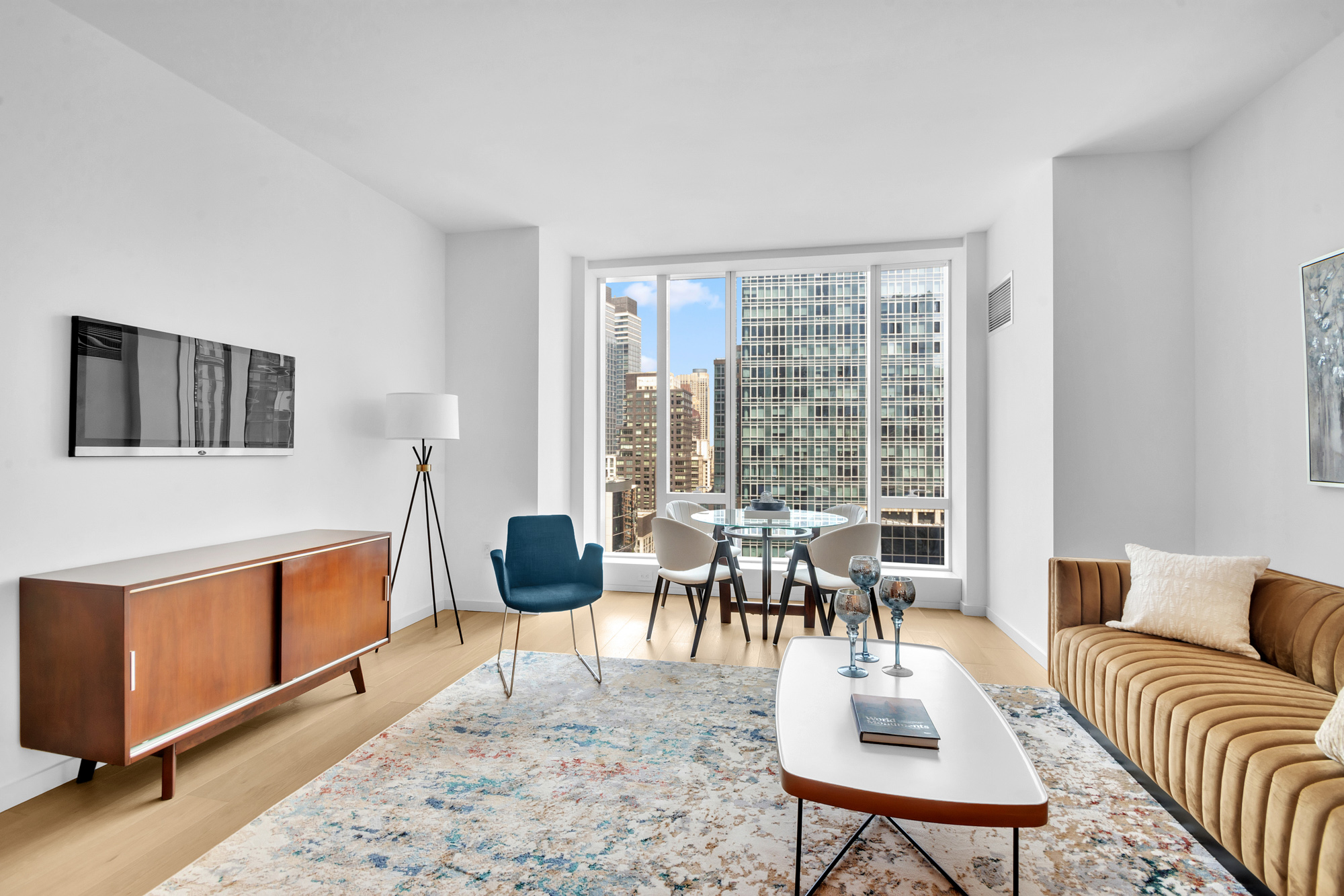 a living room with furniture a rug a lamp and a large window