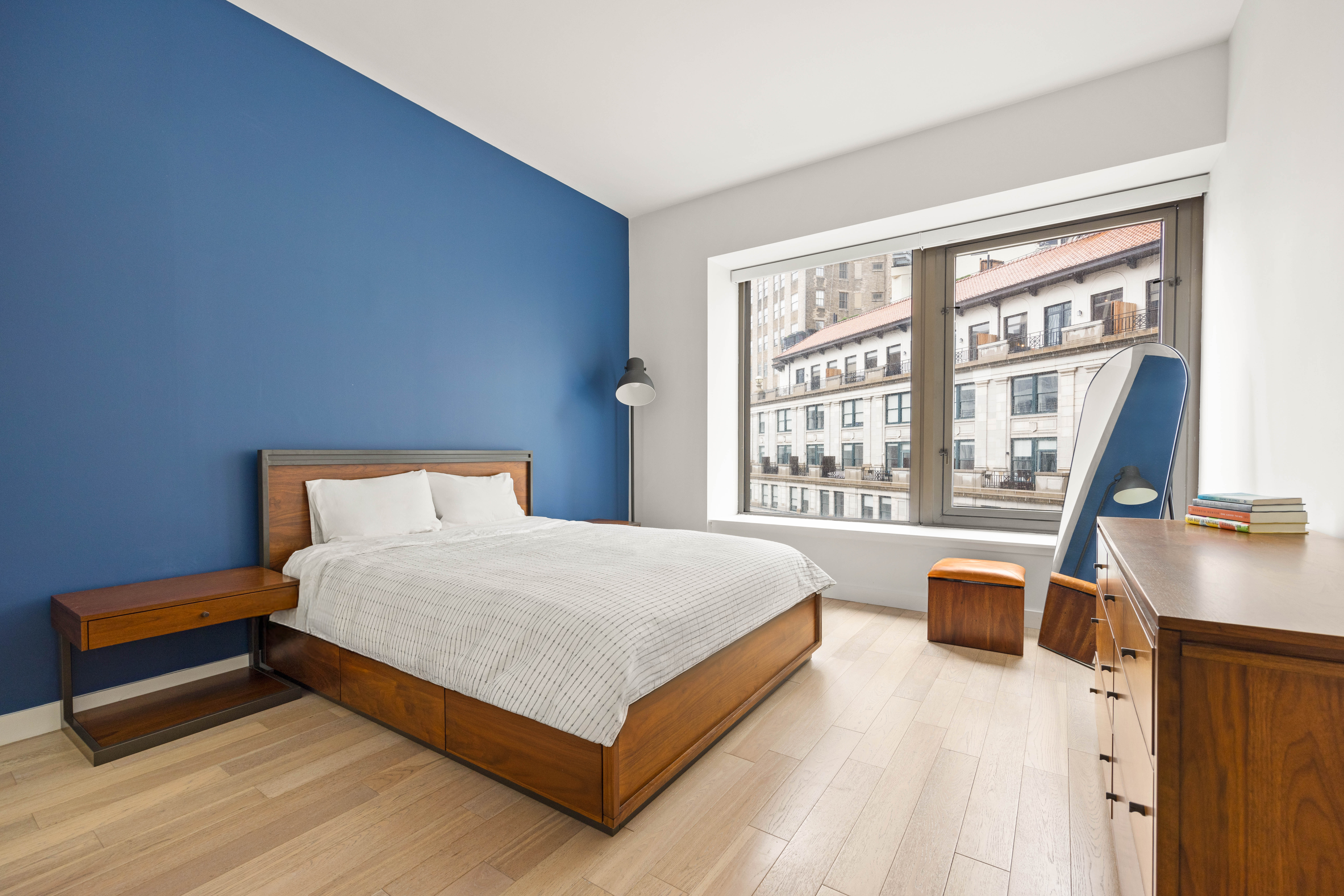 75 Wall Street, Unit 25K Manhattan, NY 10005 - Photo 5 of 9 a bedroom with a bed and a desk next to a window