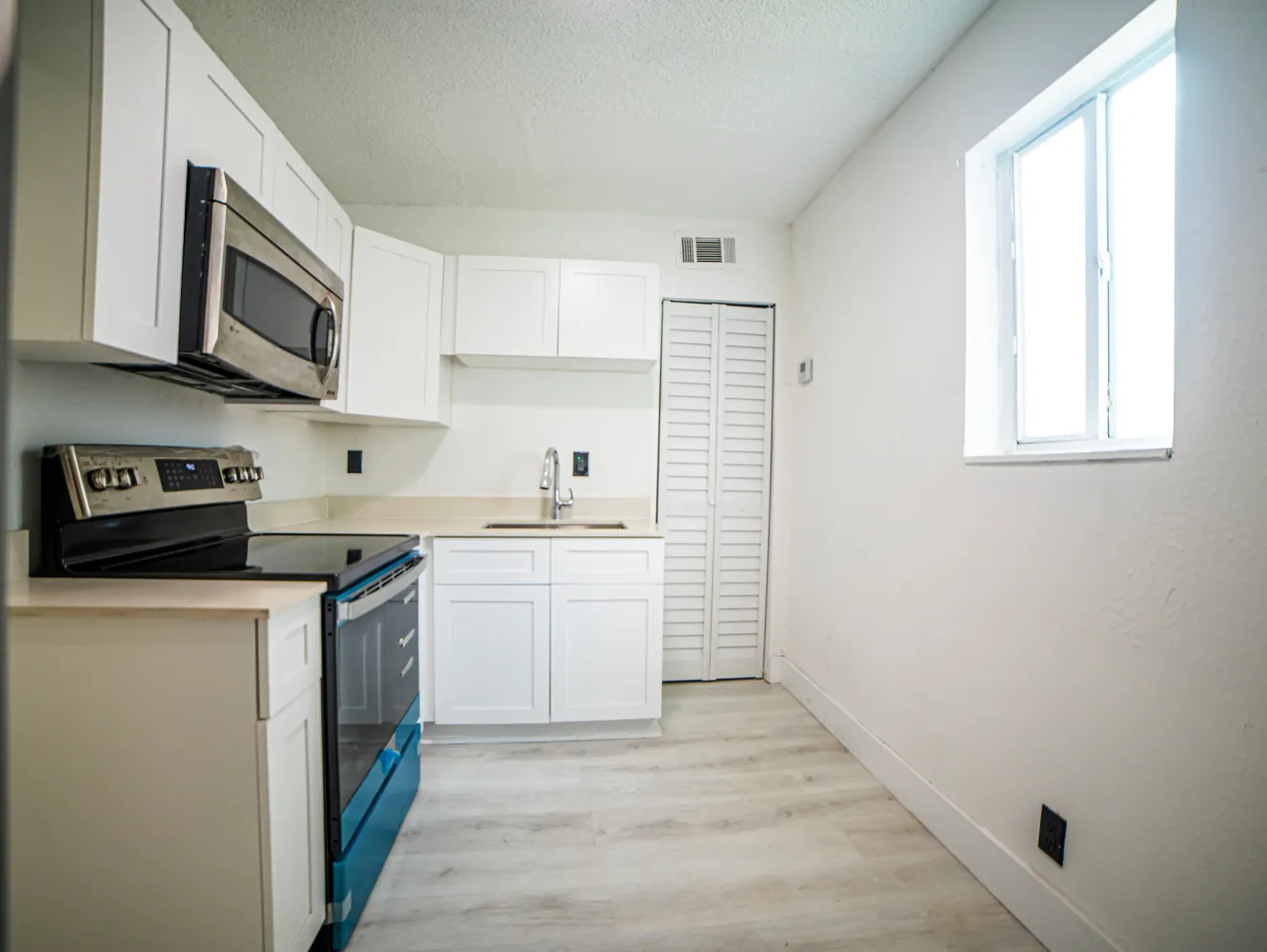 a kitchen with stainless steel appliances granite countertop a stove a sink and a microwave