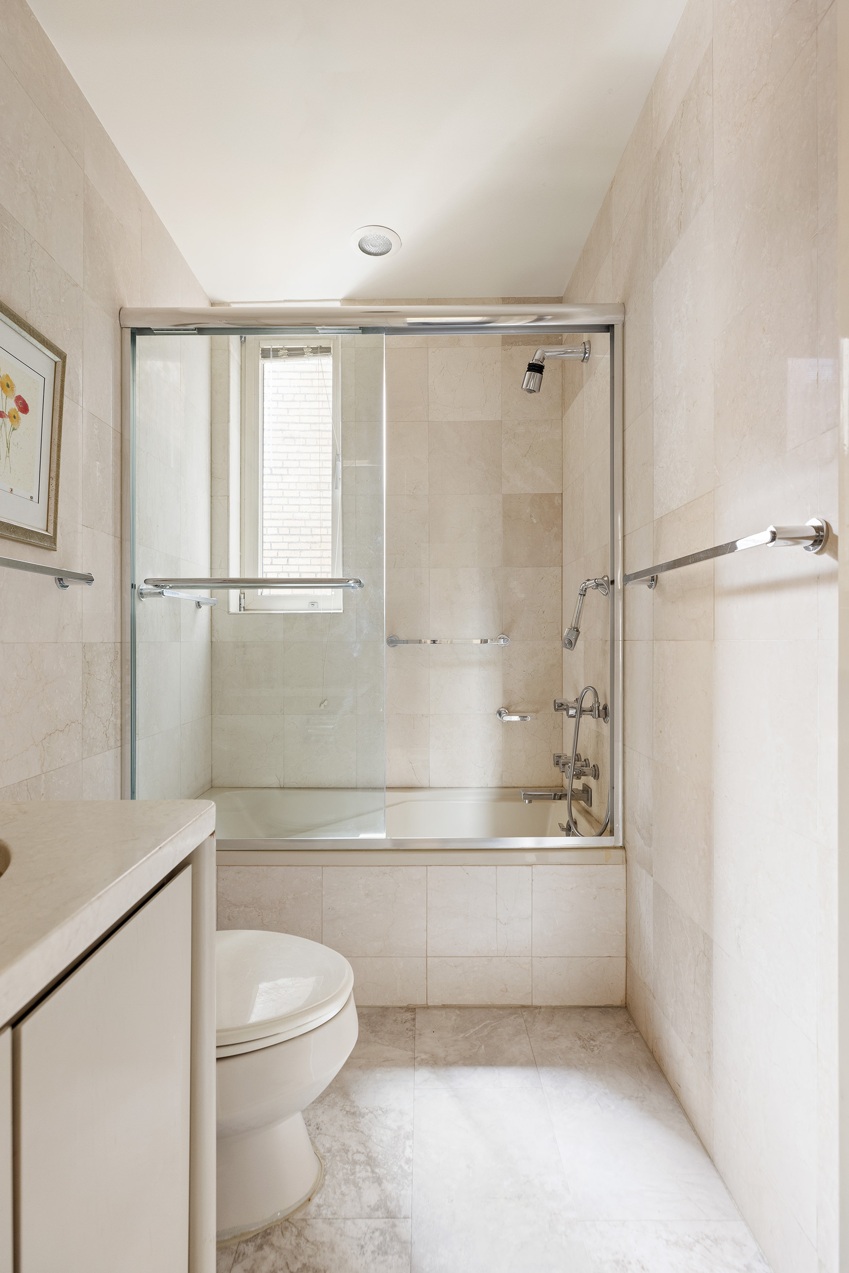 130 East 75th Street, Unit 4D Manhattan, NY 10021 - Photo 11 of 19 a bathroom with a toilet a sink and a bathtub