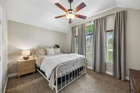 a bedroom with a bed table and a large window