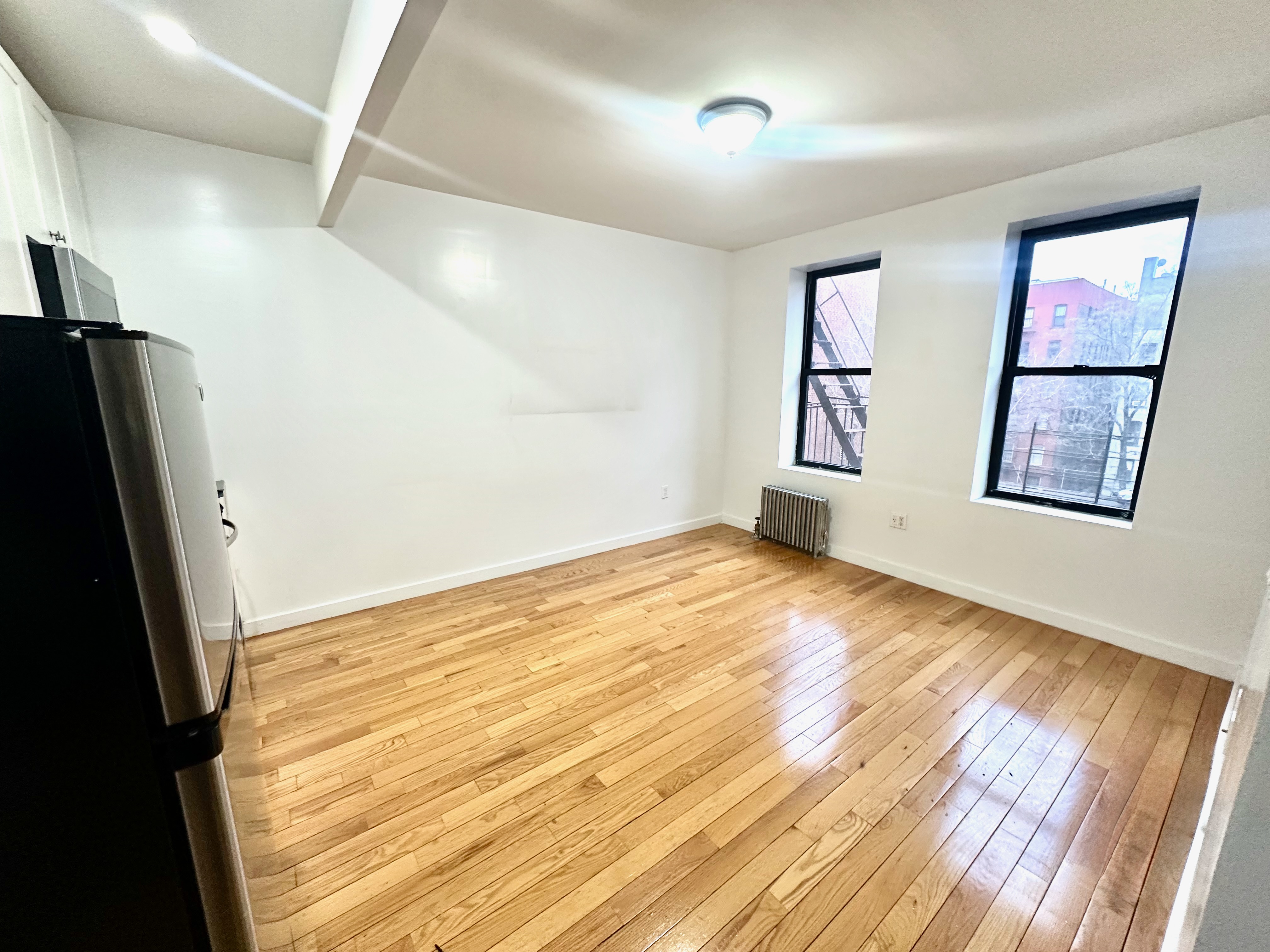 517 West 161st Street, Unit 32 Manhattan, NY 10032 - Photo 1 of 5 a view of empty room with wooden floor and fan