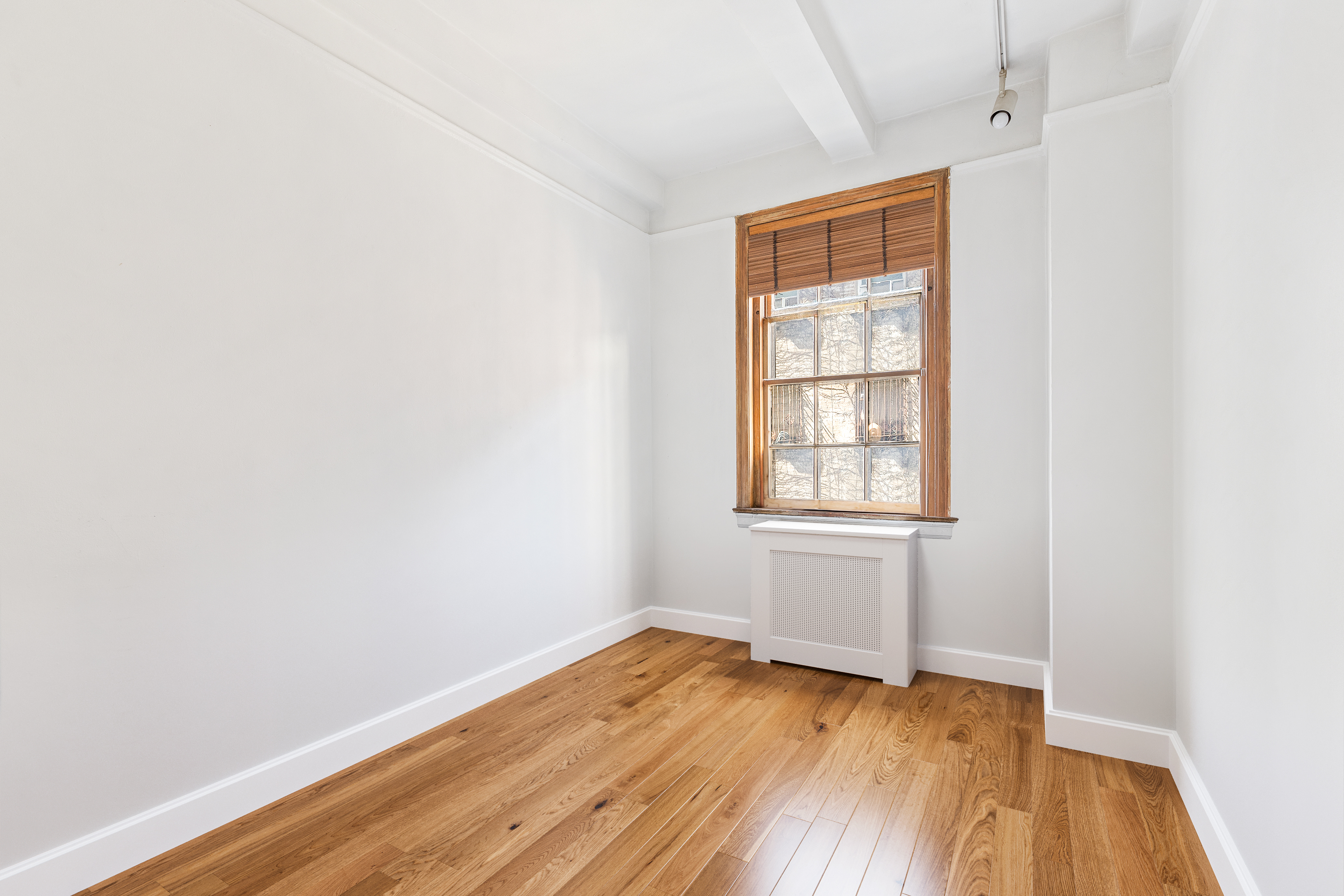 264 Lexington Avenue, Unit 4B Manhattan, NY 10016 - Photo 8 of 10 an empty room with wooden floor and windows