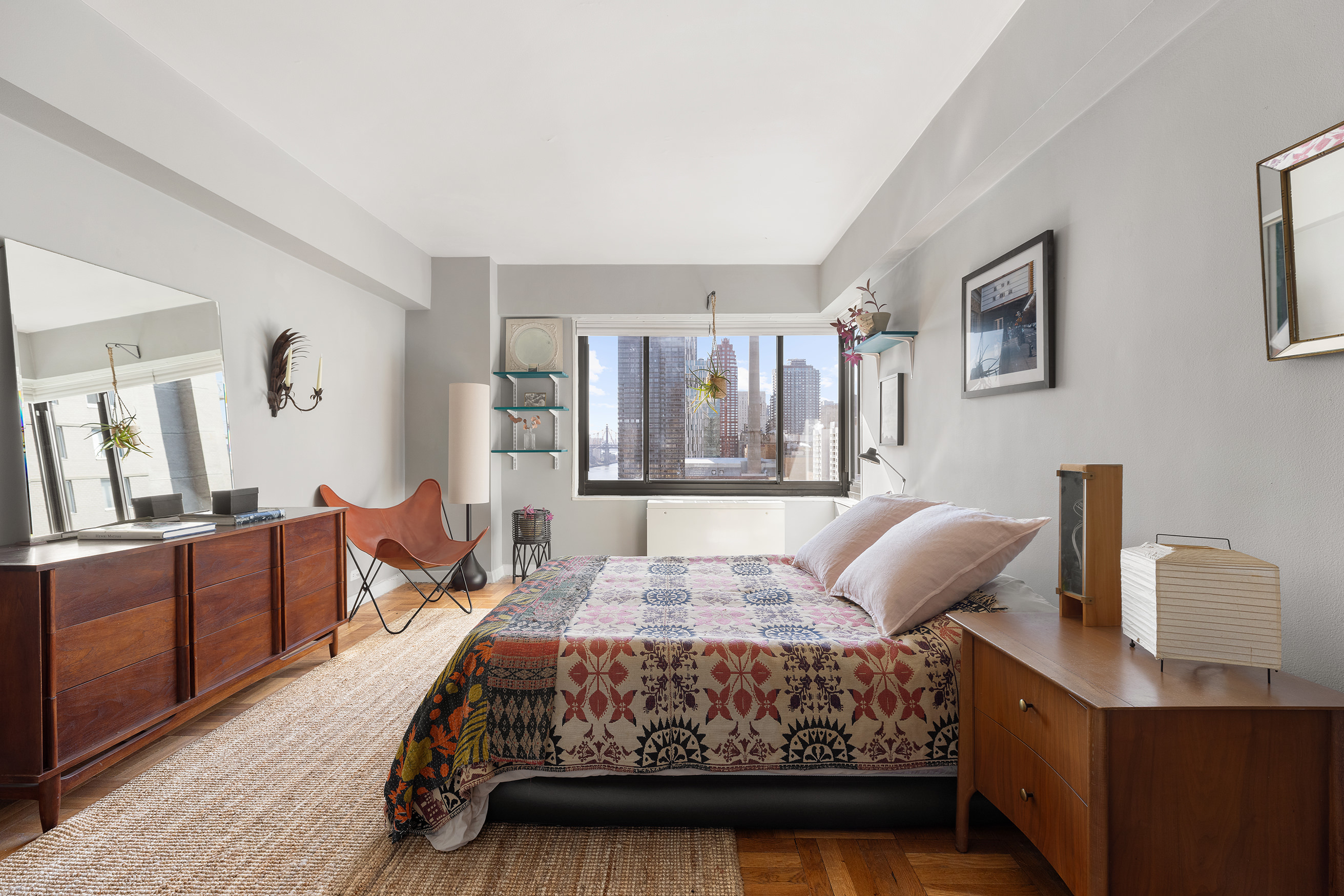 10 East End Avenue, Unit 18E Manhattan, NY 10075 - Photo 6 of 13 a bedroom with a bed and wooden floor