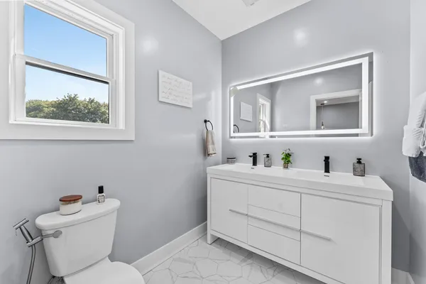 a bathroom with a toilet sink and mirror