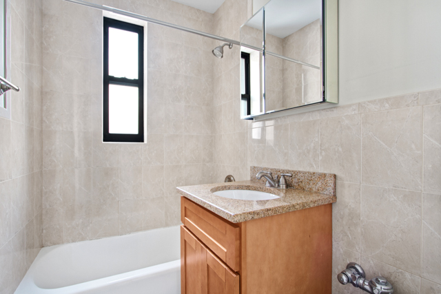 145 East 22nd Street, Unit 3D Manhattan, NY 10010 - Photo 5 of 6 a bathroom with a granite countertop sink and a bathtub