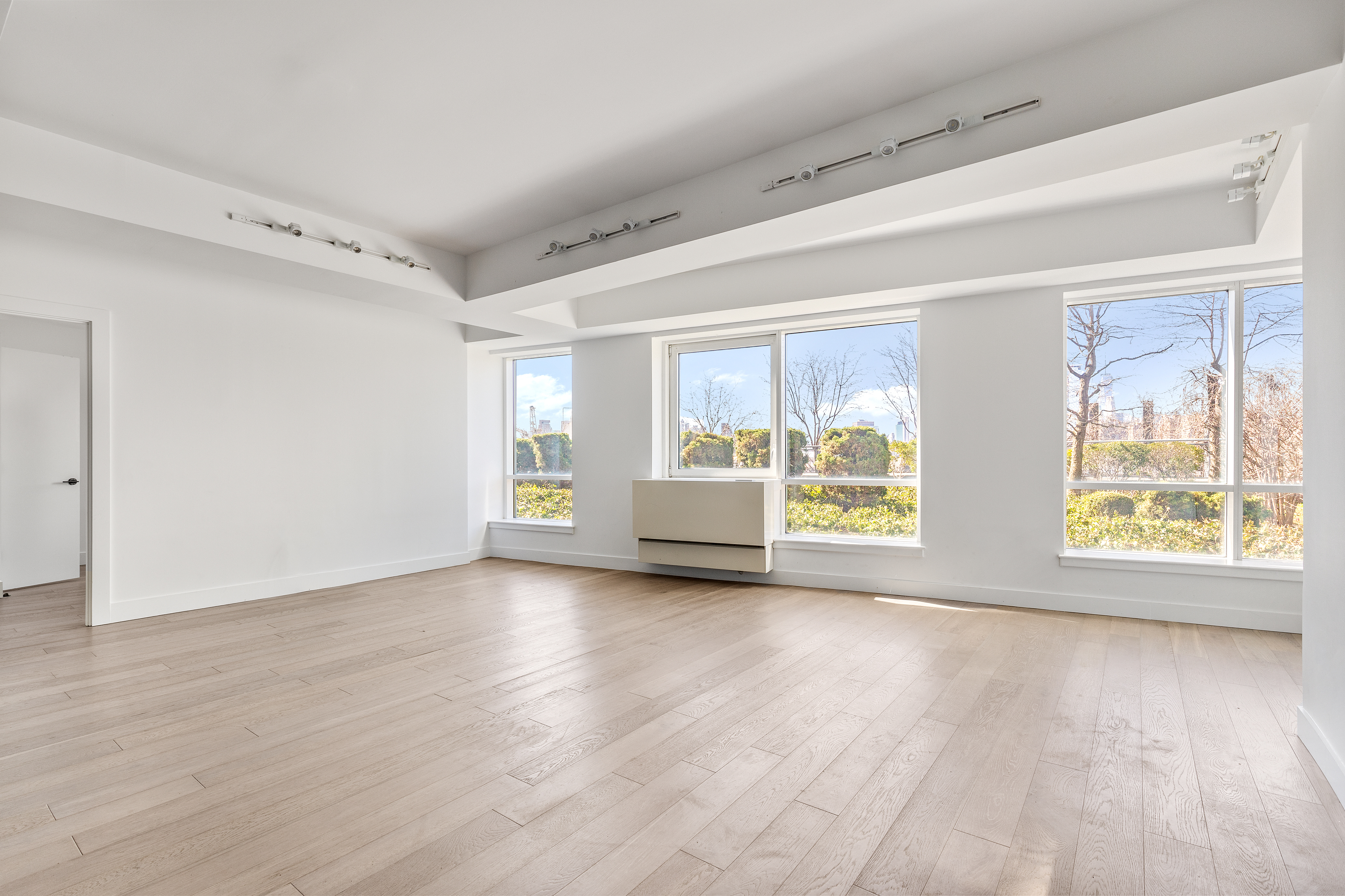 440 Kent Avenue, Unit 1B Brooklyn, NY 11249 - Photo 8 of 22 a view of an empty room with a window and wooden floor