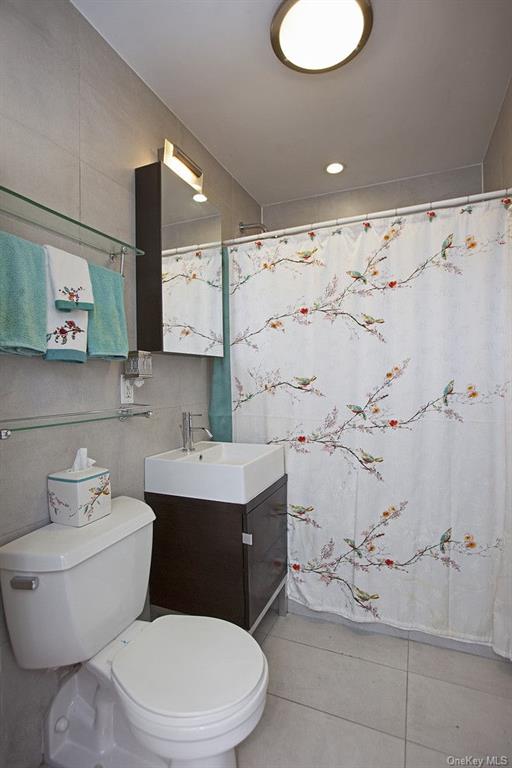 13-11 Jackson Avenue, Unit 4C Queens, NY 11101 - Photo 5 of 7 a bathroom with a toilet sink and mirror