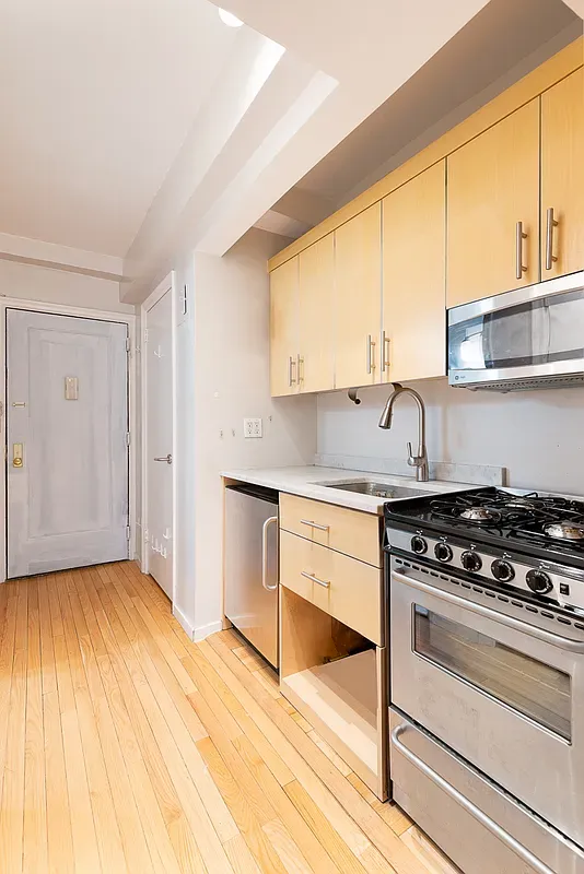 a kitchen with granite countertop a stove a sink and a microwave
