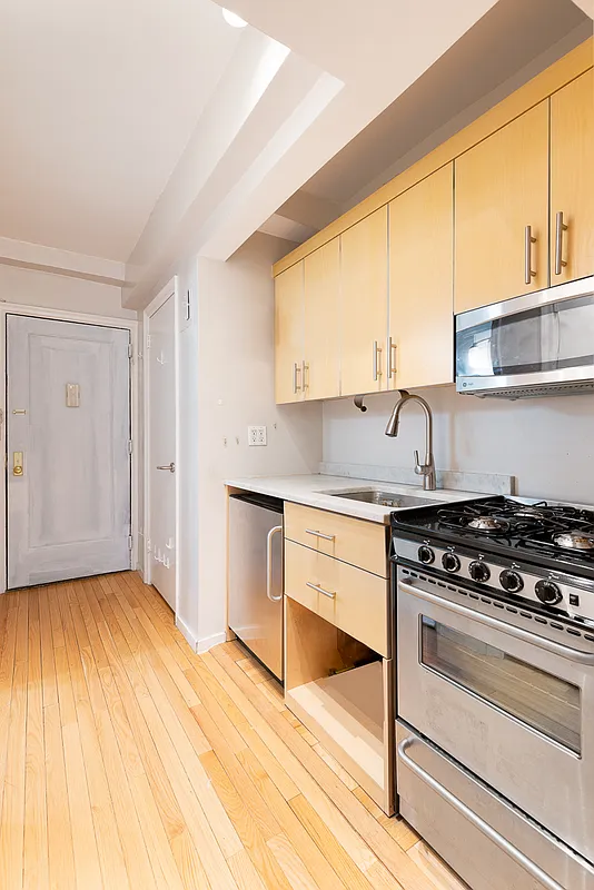 433 West 34th Street, Unit 3E Manhattan, NY 10001 - Photo 2 of 10 a kitchen with granite countertop a stove a sink and a microwave