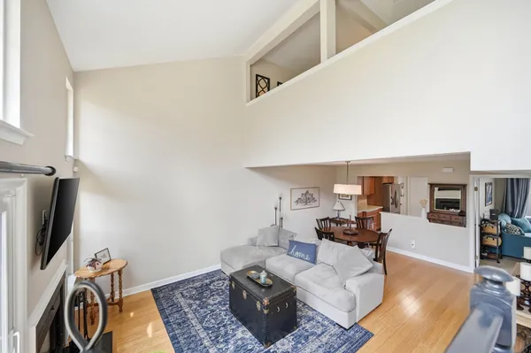 a living room with furniture a flat screen tv and kitchen view