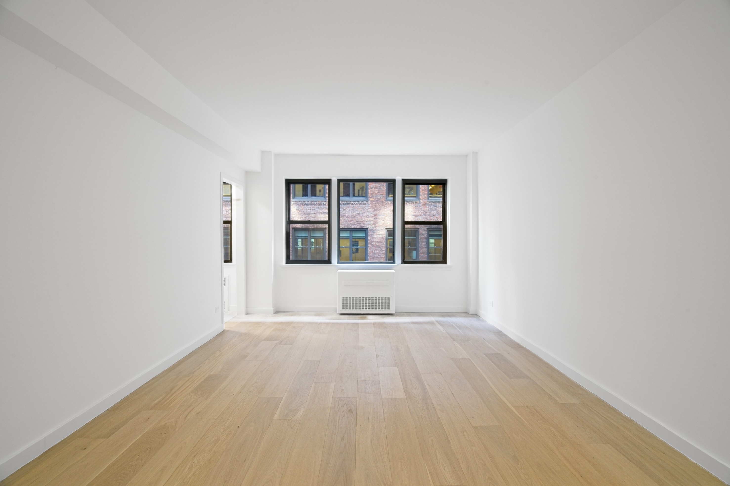 240 East 46th Street, Unit 8J Manhattan, NY 10017 - Photo 2 of 11 wooden floor in a room next to a window