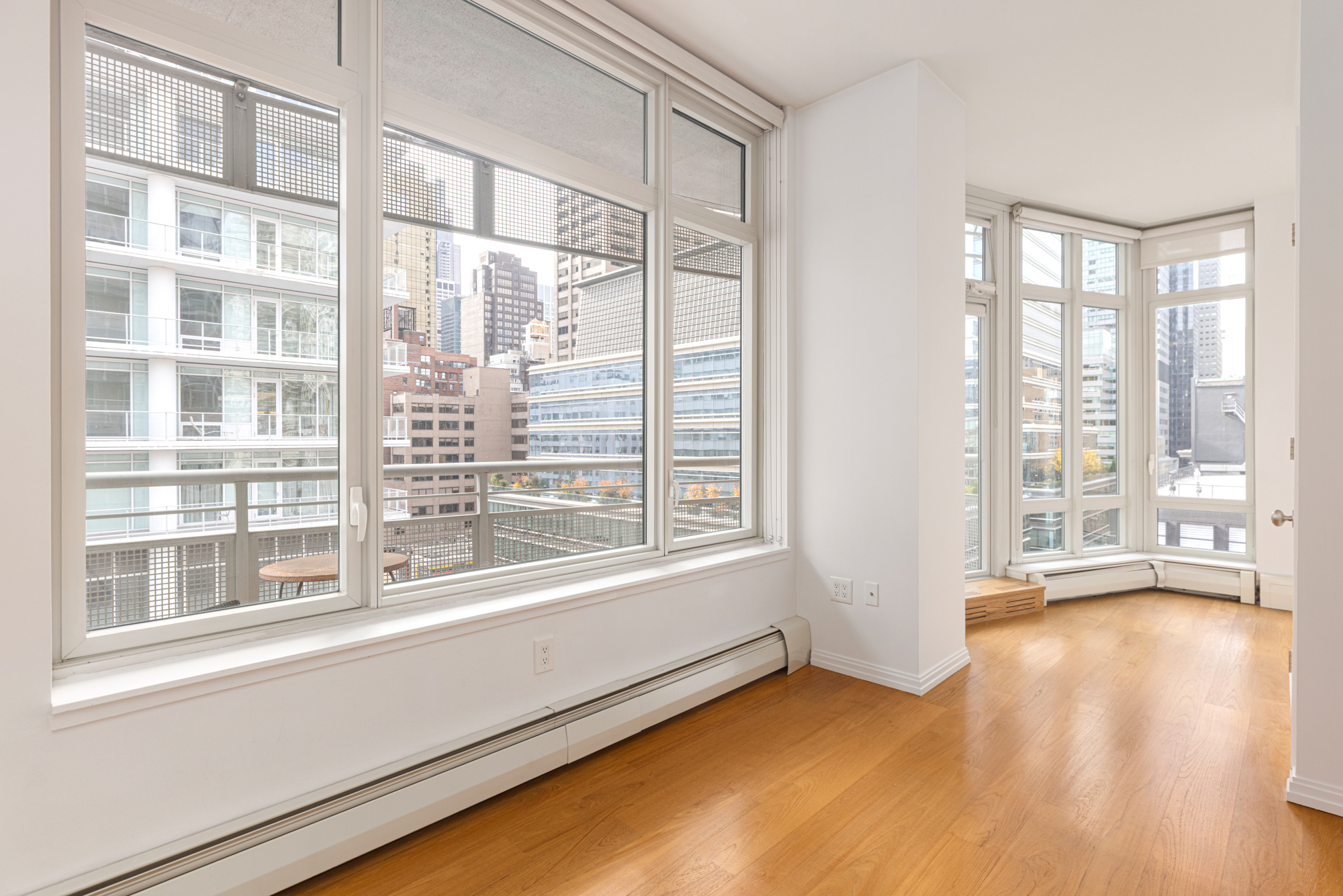 205 East 59th Street, Unit 10B Manhattan, NY 10022 - Photo 6 of 10 a view of an empty room with a window and wooden floor