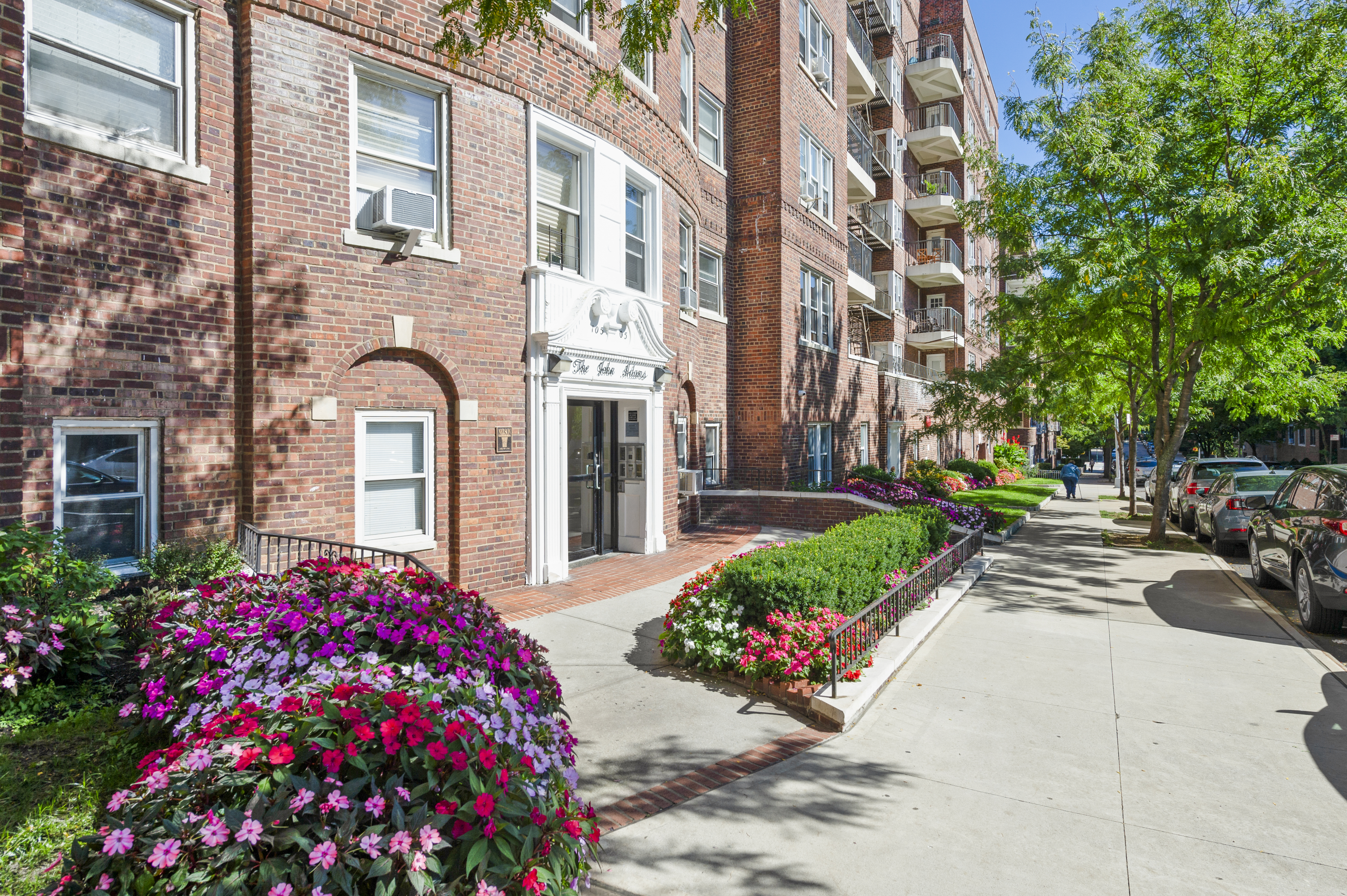 105-05 69th Avenue, Unit 301 Queens, NY 11375 - Photo 13 of 13 a front view of a building with garden and flowers