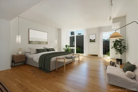 a spacious bedroom with a bed and wooden floor