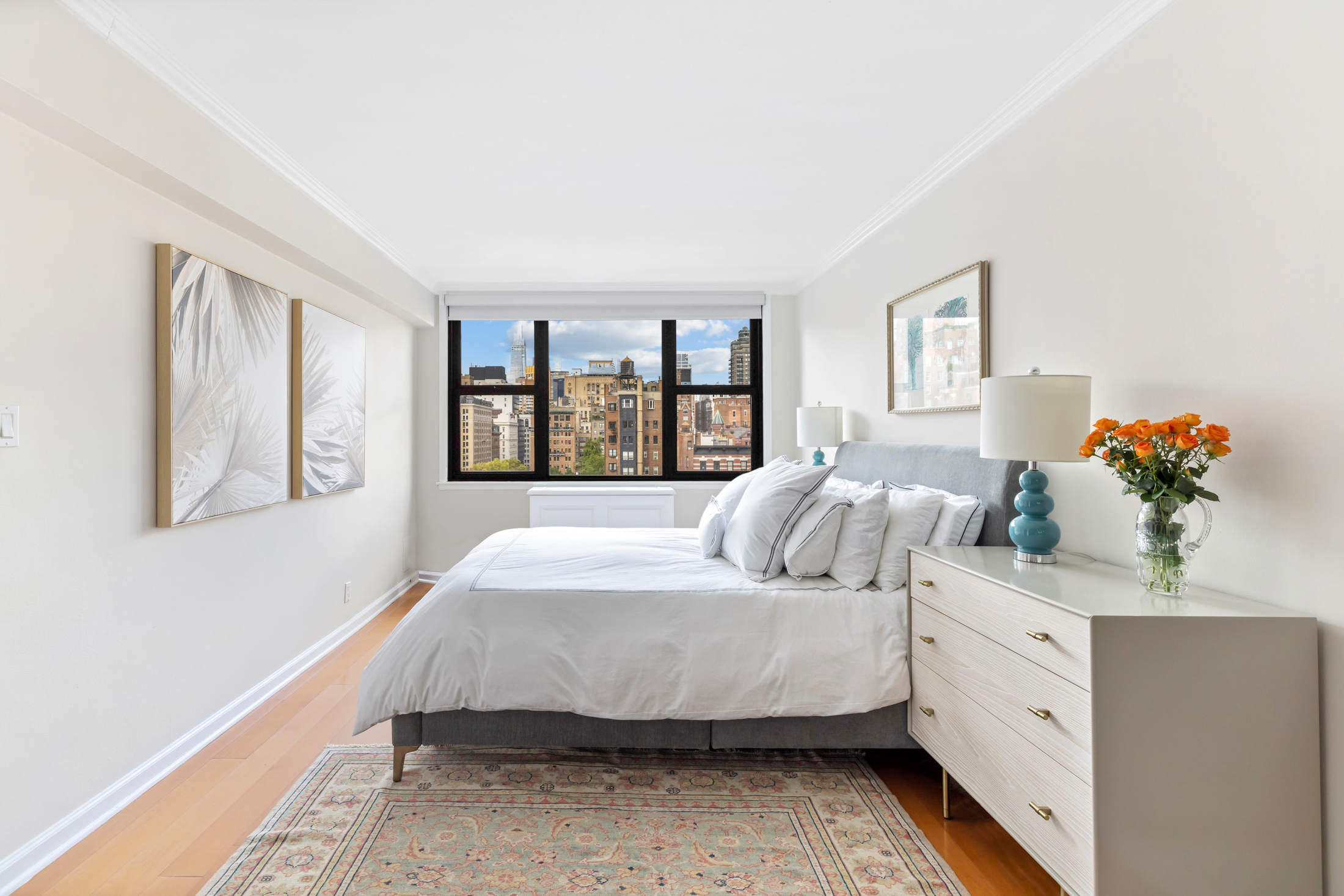 130 East 18th Street, Unit 14B Manhattan, NY 10003 - Photo 5 of 8 a bedroom with a large bed and a chandelier