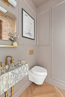 a bathroom with a toilet sink and mirror